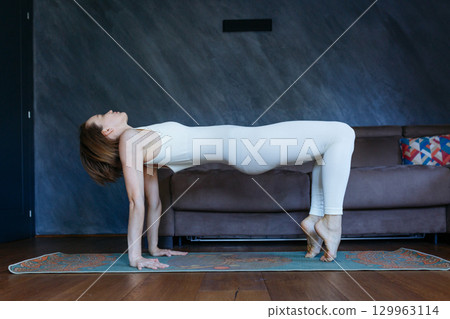 woman in Reverse Table yoga pose at home 129963114