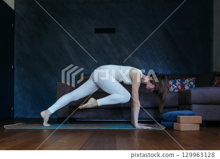 woman doing Forearm Plank yoga pose at home 129963128