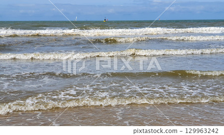 Beautiful sea with sand, yachts, waves on the water and blue sky. Natural background for summer vacation. Beautiful sea with sand, yachts, waves on the water and blue sky. Natural background for summer vacation. 129963242