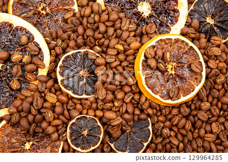 Coffee beans and dried orange slices create a unique aromatic blend in a decorative arrangement Coffee beans and dried orange slices create a unique aromatic blend in a decorative arrangement 129964285