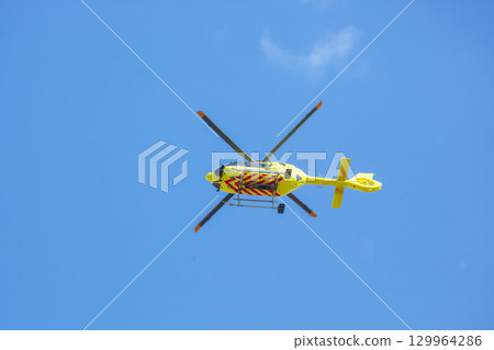 Helicopter flying high in a clear blue sky during daylight hours Helicopter flying high in a clear blue sky during daylight hours 129964286