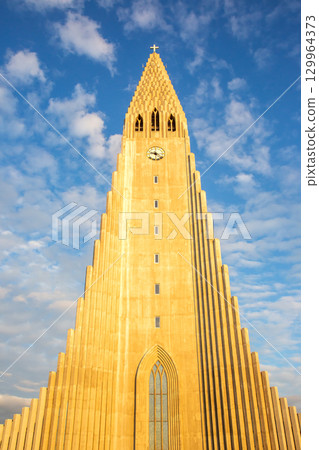 Landmark church in Reykjavik showcasing stunning architecture against a blue sky 129964373