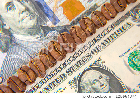 Coffee beans arranged on a US dollar bill illustrating the value of a good brew 129964374