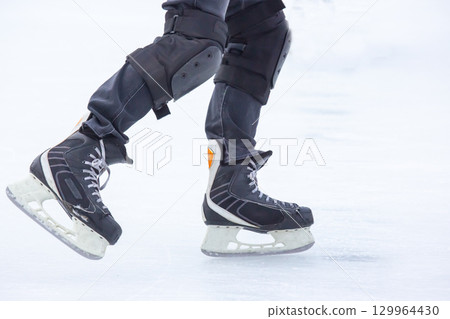 Skater practicing on outdoor ice rink during winter day in bright conditions Skater practicing on outdoor ice rink during winter day in bright conditions 129964430