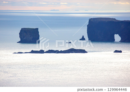 Stunning coastal rock formations in Iceland reflecting the serene hues of the Atlantic Ocean 129964446