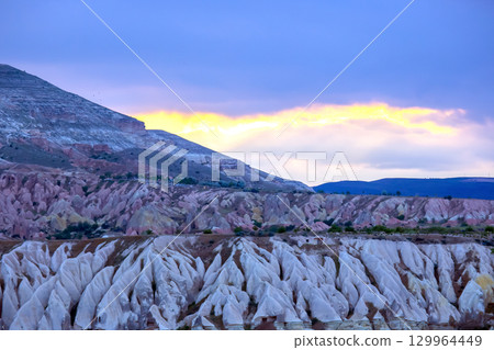 Sunset over unique rock formations in Cappadocia, Turkey, showcasing natural beauty Sunset over unique rock formations in Cappadocia, Turkey, showcasing natural beauty 129964449