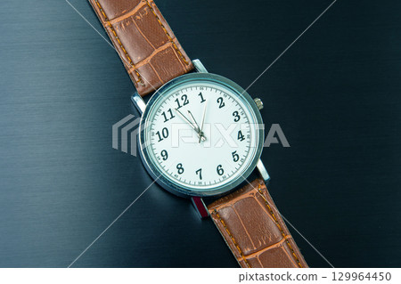 Elegant brown leather strap watch with silver face and classic design Elegant brown leather strap watch with silver face and classic design 129964450