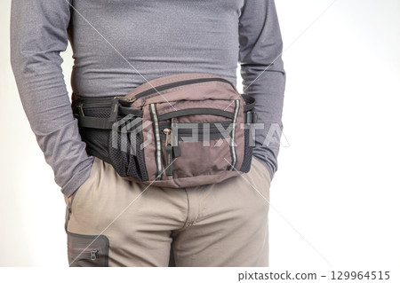 Fashionable waist bag worn by an individual during casual outdoor activities Fashionable waist bag worn by an individual during casual outdoor activities 129964515