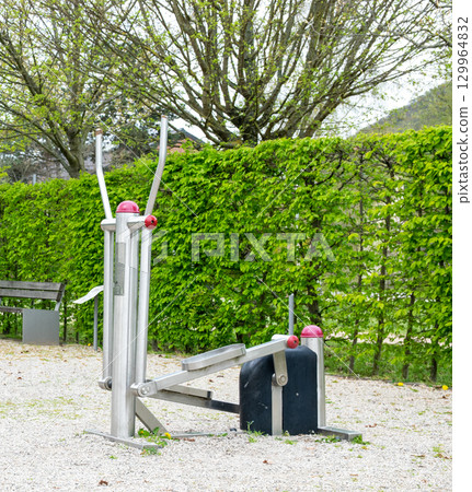 Fitness corner with equipment outside, under the open sky. Gym machines for exercising, sport and bodybuilding. Sports background. Fitness corner with equipment outside, under the open sky. Gym machines for exercising, sport and bodybuilding. Sports background. 129964832
