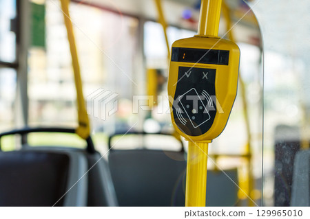Modern Bus Interior with Payment Terminal and Yellow Grab Handle 129965010