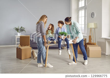 Happy family on moving day on a new home with unpacked boxes. Happy family on moving day on a new home with unpacked boxes. 129966775