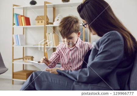 Woman psychologist working with preschooler boy during therapy session Woman psychologist working with preschooler boy during therapy session 129966777