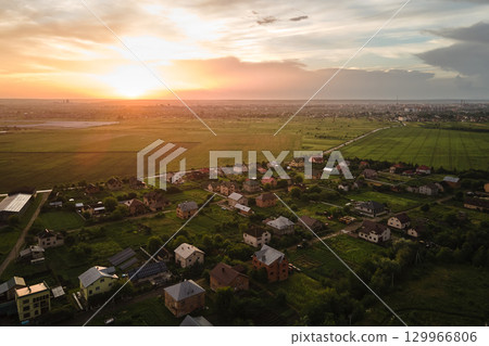 Aerial view of residential houses in suburban rural area at sunset 129966806