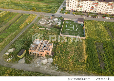 Aerial view of building site for future house, brick basement floor and stacks of brick for construction. 129966810