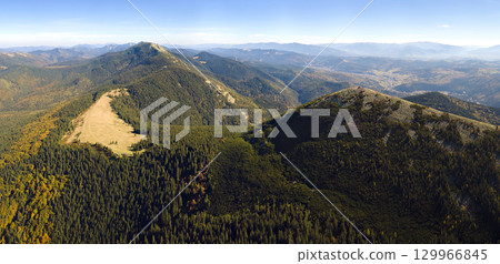 Aerial landscape view of high peaks with dark pine forest trees in wild mountains 129966845