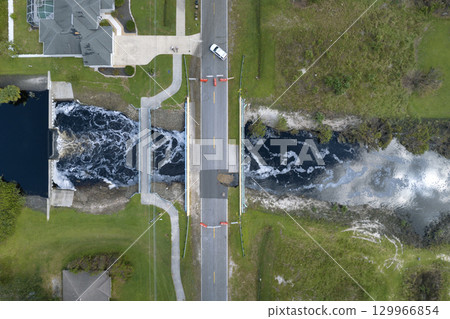 Police car roadblock at damaged road bridge destroyed by river after flood water washed away asphalt. Rebuilding of ruined transportation infrastructure 129966854
