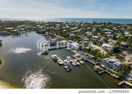 Expensive waterfront houses between green palm trees in Boca Grande, small town on Gasparilla Island in southwest Florida. Premium housing development in the USA 129966884