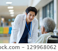 A Japanese male doctor talking to a patient in a wheelchair 129968062