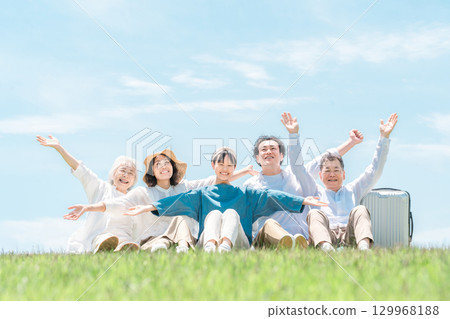 一個可以看到藍天的公園,一個坐在山上的家庭,父母和孩子,一個三代家庭(父親,母親,女兒,祖母,祖父) 一個可以看到藍天的公園,一個坐在山上的家庭,父母和孩子,一個三代家庭(父親,母親,女兒,祖母,祖父) 129968188