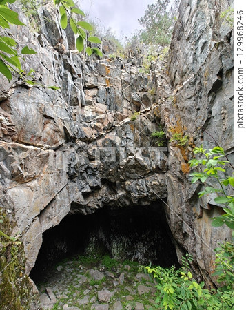 Mysterious Cave Entrance Amidst Rocky Terrain A Geological Wonder and Natural Hideaway Mysterious Cave Entrance Amidst Rocky Terrain A Geological Wonder and Natural Hideaway 129968246