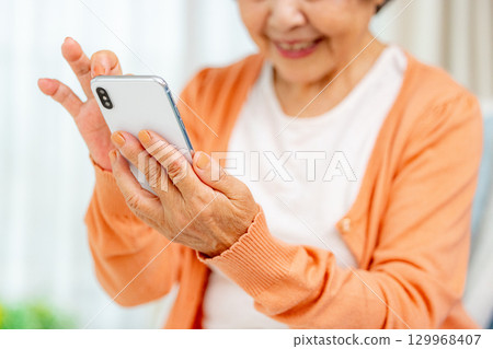 Senior woman operating a smartphone Senior woman operating a smartphone 129968407