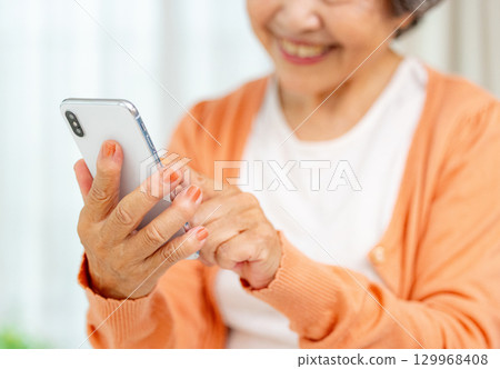 操作智能手機的資深婦女 129968408