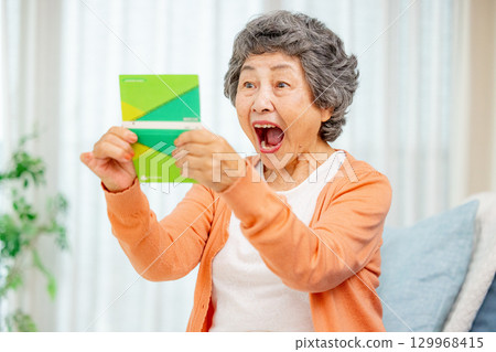 Senior woman holding a bankbook Senior woman holding a bankbook 129968415