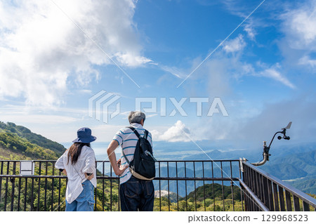 岐阜縣關原町伊吹山車道停車場的觀景台上,兩人正眺望著下面的世界 岐阜縣關原町伊吹山車道停車場的觀景台上,兩人正眺望著下面的世界 129968523