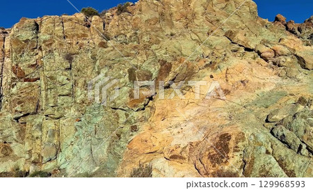 The breathtaking rocky terrain is majestically surrounded by a vast and clear blue sky above 129968593