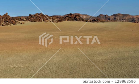 This stunning desert landscape features impressive rock formations set beneath a clear blue sky 129968596