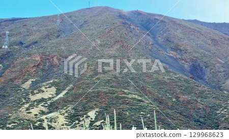 A Stunning Mountain Landscape Featuring Power Lines Beneath a Beautiful Clear Sky 129968623