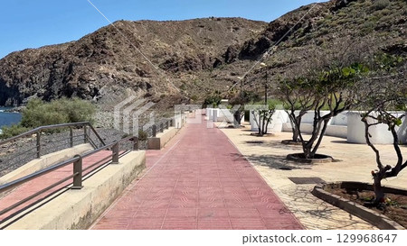 A stunning and scenic coastal pathway located beautifully near majestic mountains and the sea 129968647