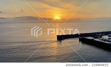 A Serene Sunset Over Calm Waters at the Beautiful Harbor Offers a Truly Breathtaking View 129968655