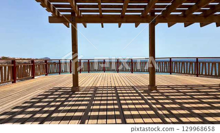 Enjoy a stunning ocean view from a spacious deck adorned with a beautiful pergola 129968658