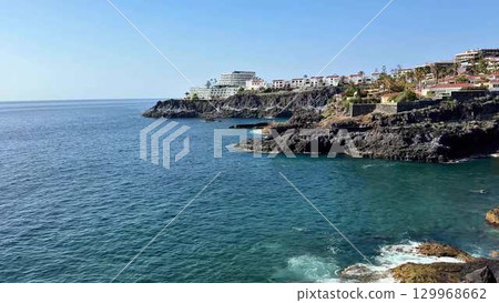 Stunning Coastal View Featuring Serene Waters Surrounded by Majestic Rocky Cliffs 129968662