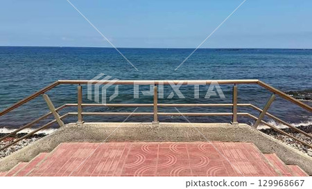 Experience a breathtaking and scenic view of the ocean from a charming coastal boardwalk Experience a breathtaking and scenic view of the ocean from a charming coastal boardwalk 129968667