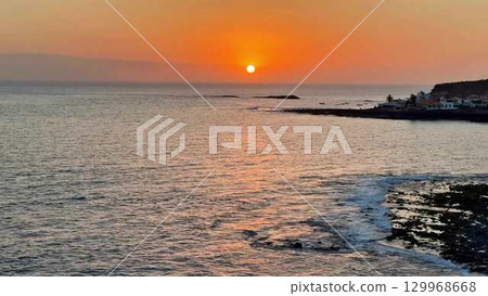 A Breathtaking, Stunning Sunset Over the Calm Ocean Waters Captured Perfectly in Time 129968668