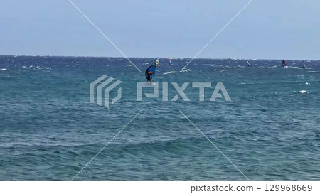 Engaging Dynamic Surfing Scene Over Stunningly Clear and Crystal Blue Waters of the Ocean 129968669