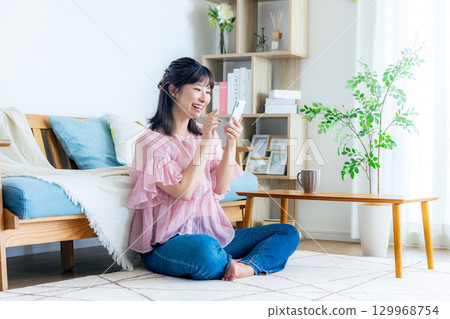 一個操作智能手機的年輕女子 129968754
