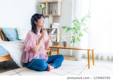 A young woman operating a smartphone 129968760