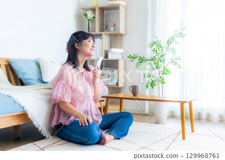 A young woman operating a smartphone 129968761
