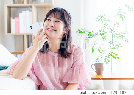 一個操作智能手機的年輕女子 129968763
