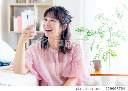 一個操作智能手機的年輕女子 129968764