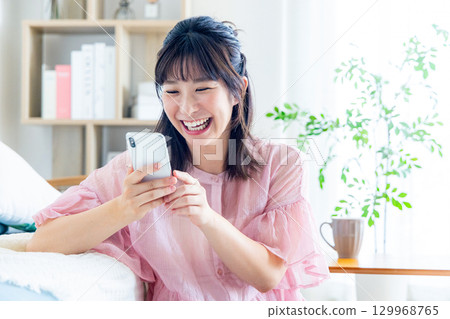 一個操作智能手機的年輕女子 129968765