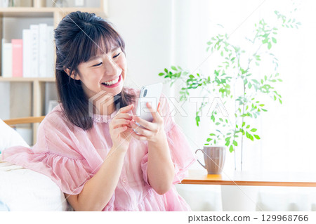 一個操作智能手機的年輕女子 129968766