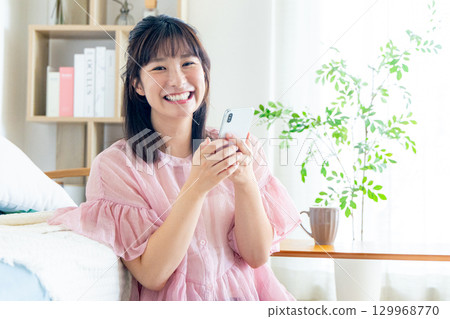 A young woman operating a smartphone A young woman operating a smartphone 129968770