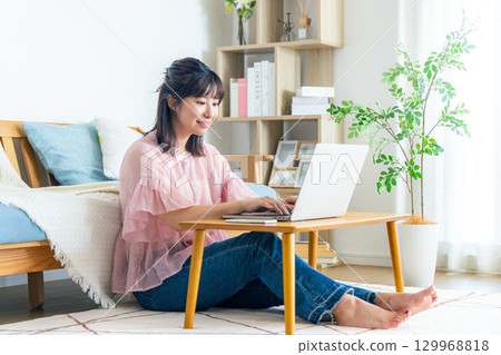 一位女士在客廳使用電腦 129968818