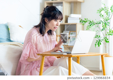 一位女士在客廳使用電腦 129968834