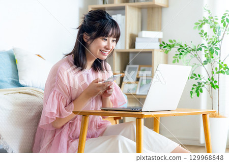 在客廳裡使用智能手機的年輕女子 129968848