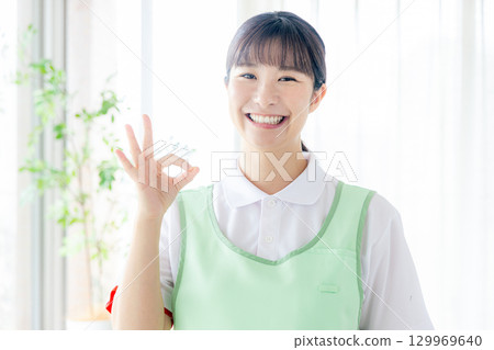 一個圍裙的年輕女士 129969640